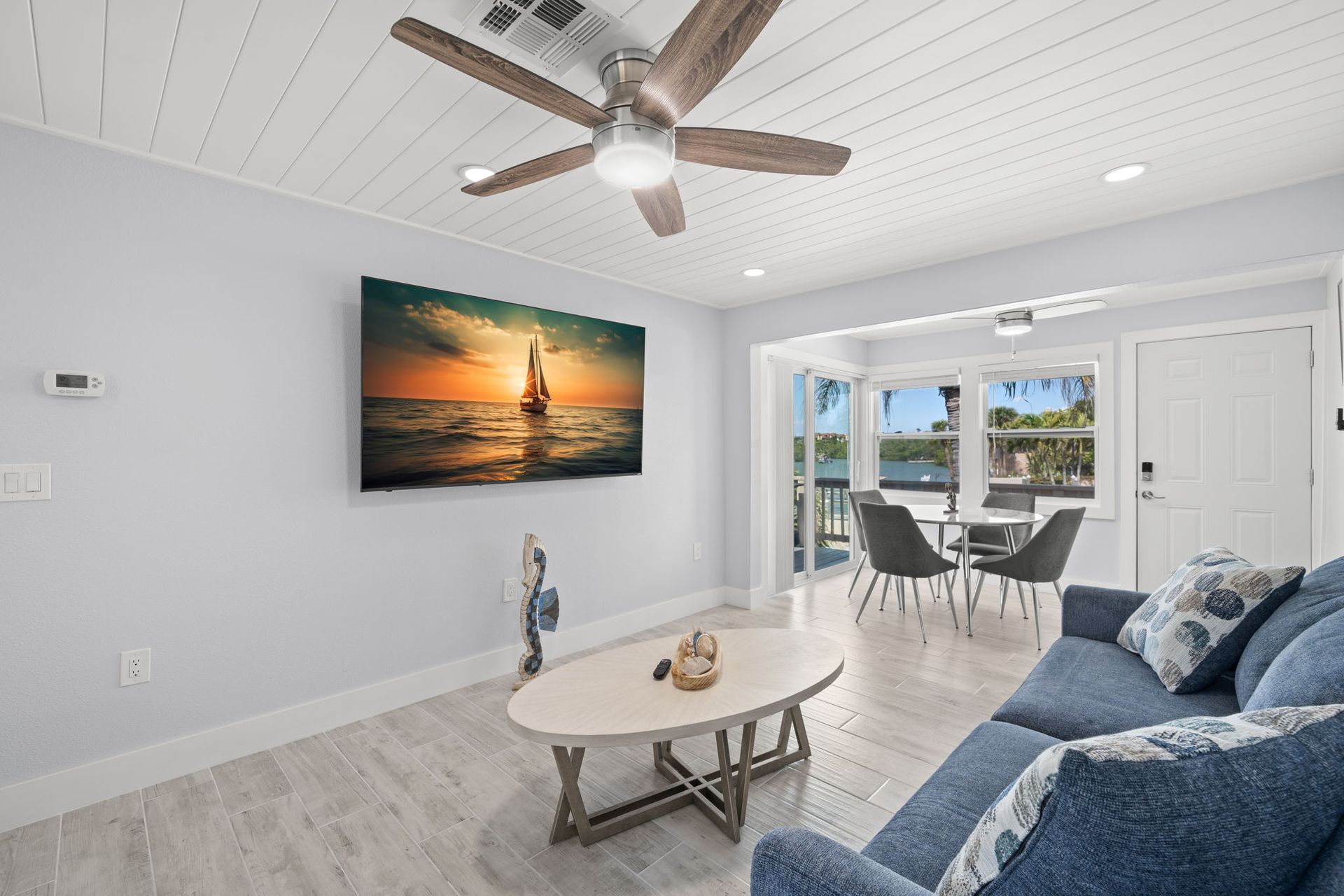 A living room with a couch , coffee table , and ceiling fan.