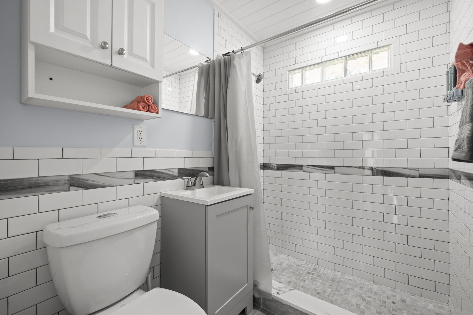 A bathroom with a toilet , sink , and shower.
