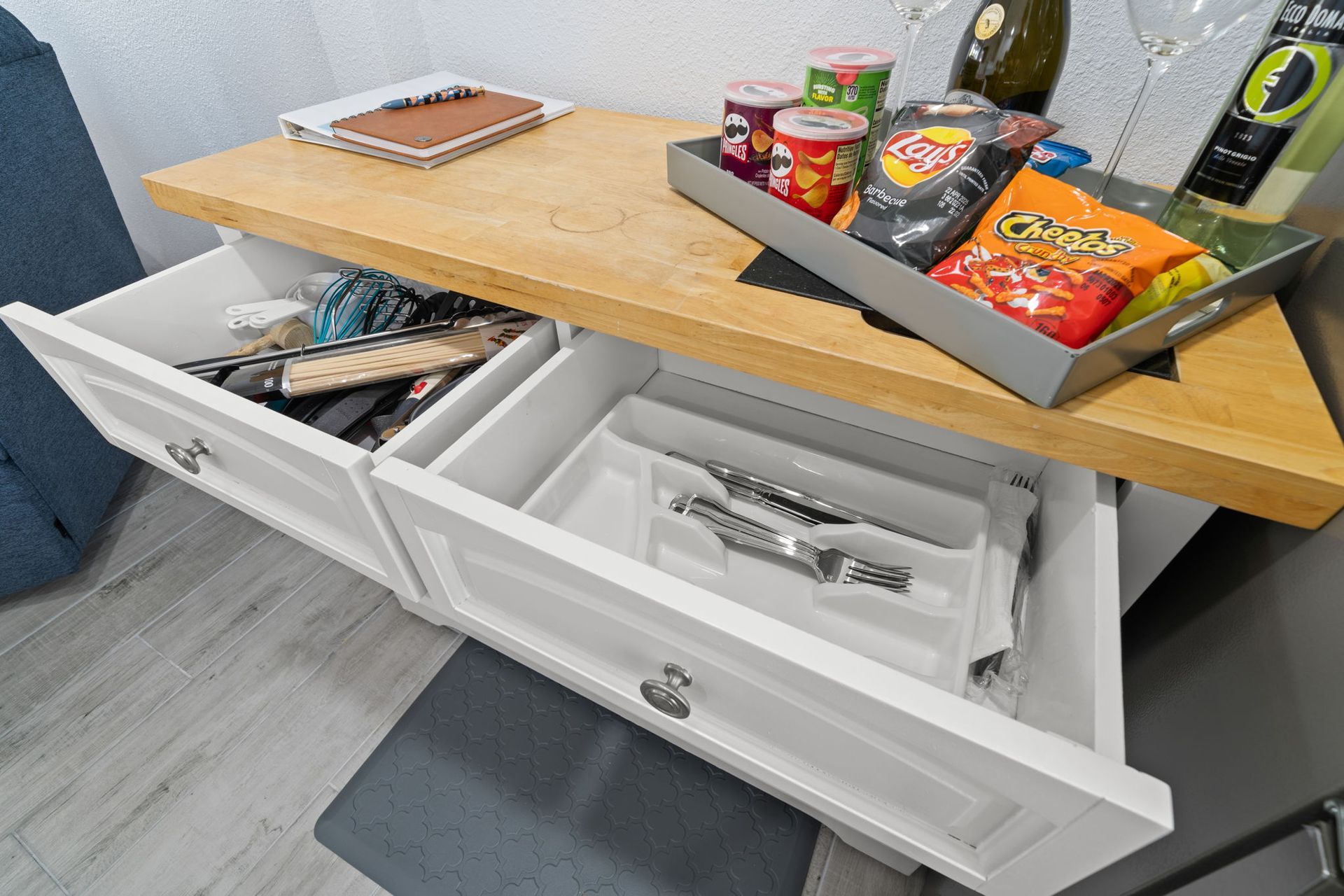 A kitchen counter with a tray of chips and a bottle of wine.