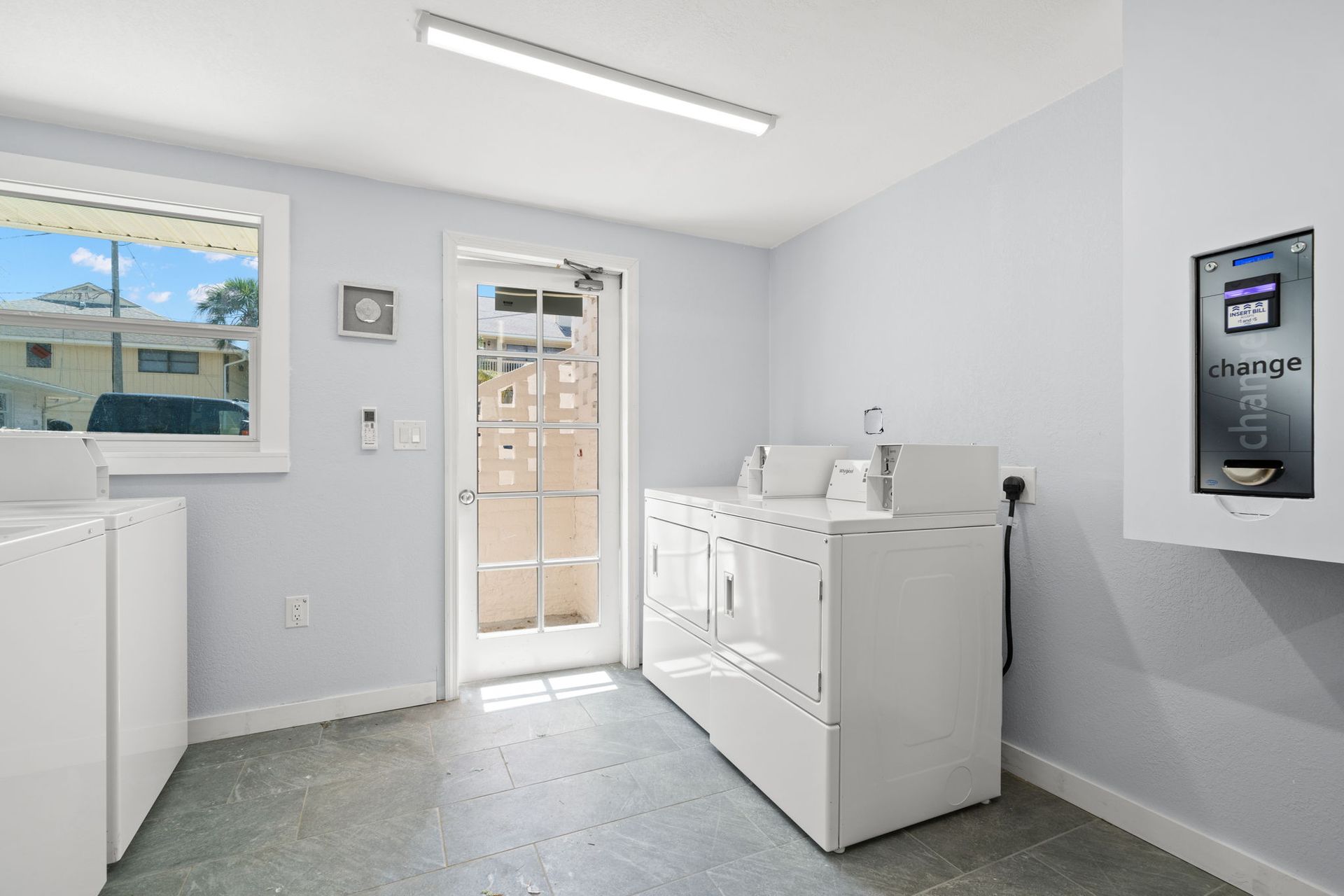 A laundry room with a washer and dryer and a window.