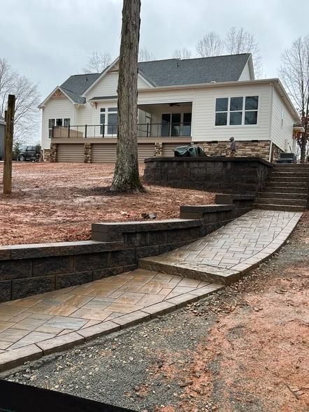 House with stone steps and retaining walls on a bare landscaped yard