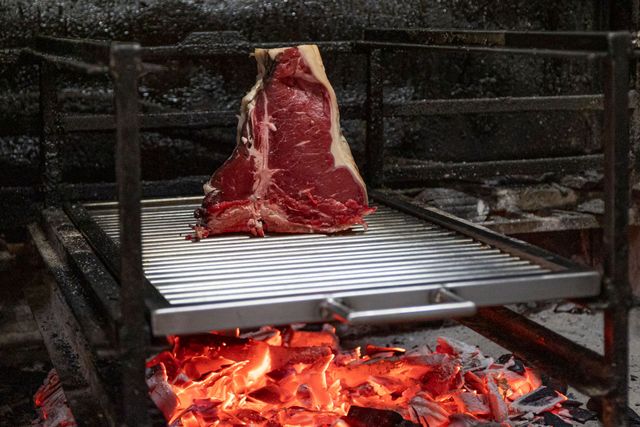 Macellaio della famiglia Liberati che prepara un taglio di carne al banco a Poggio Nativo