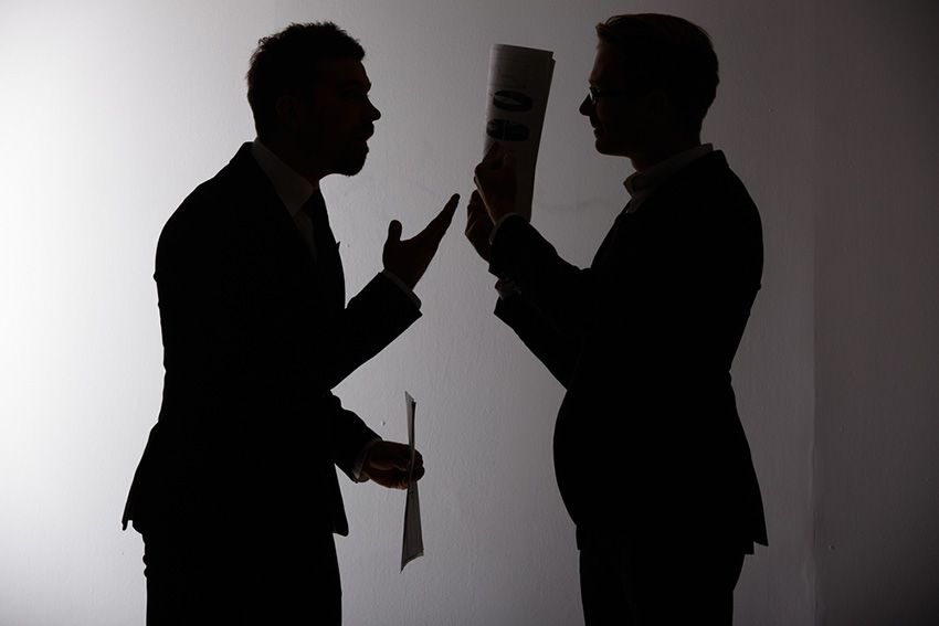 A Silhouette of Two Men Standing Next to Each Other — Budd & Piper Solicitors & Conveyancers in Tweed Heads, NSW