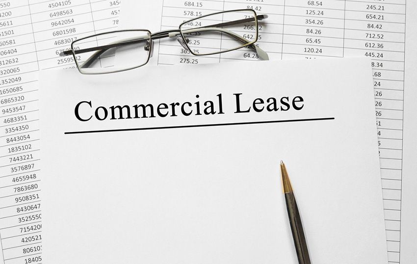 A Glasses is Top of a Piece of Paper That Says Commercial Lease — Budd & Piper Solicitors & Conveyancers in Tweed Heads, NSW