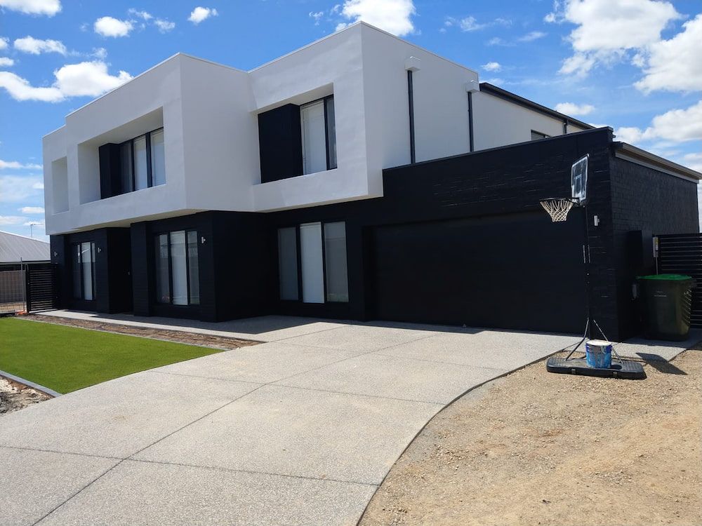 A Black and White House With a Basketball Hoop in Front of It — Shields Painting & Decorating in Wagga Wagga, NSW