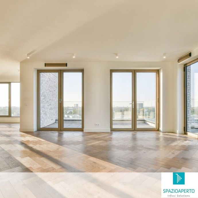 Luminosa stanza moderna e vuota con pavimento in legno e ampie porte e finestre in vetro con vista sulla città.