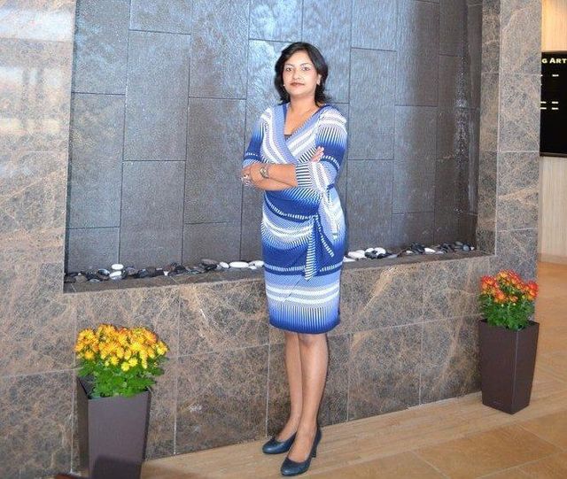 Dr. Priyanka Sharma  stands in front of a wall