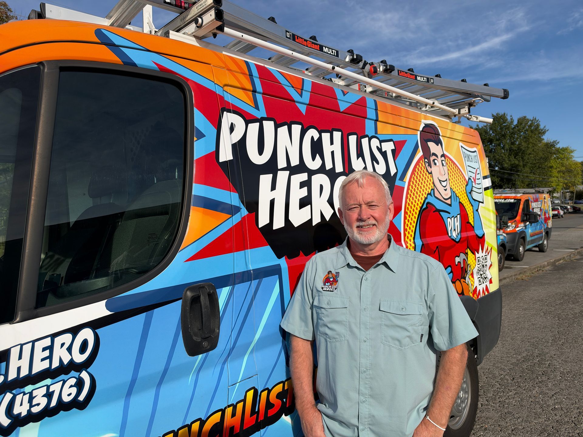 A young man is standing in front of a colorful van.