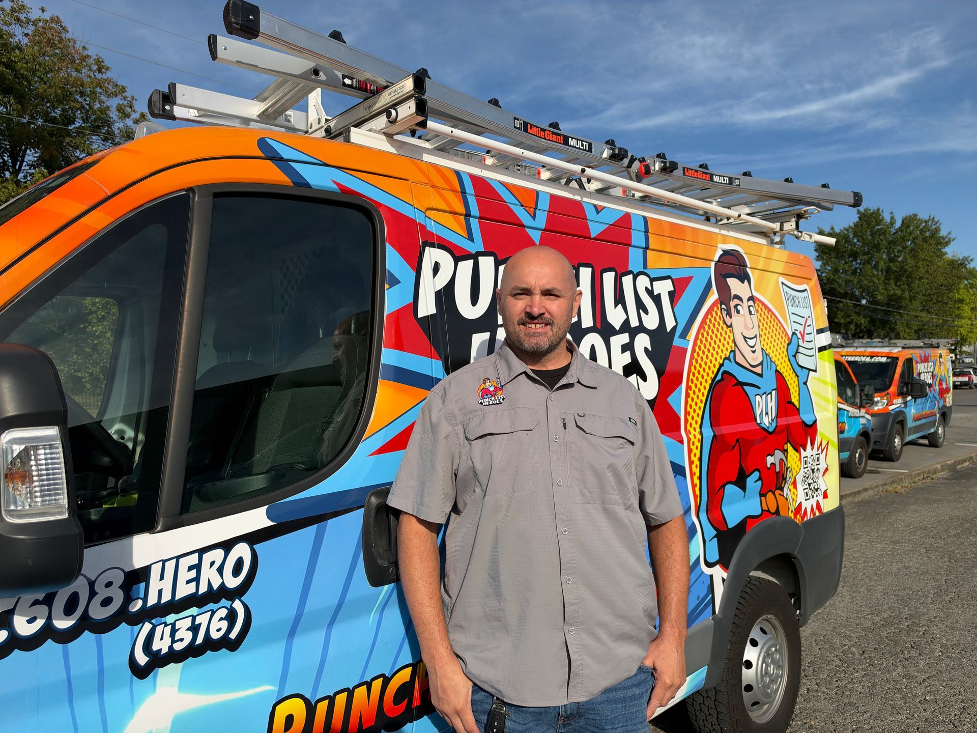 A young man is standing in front of a colorful van.