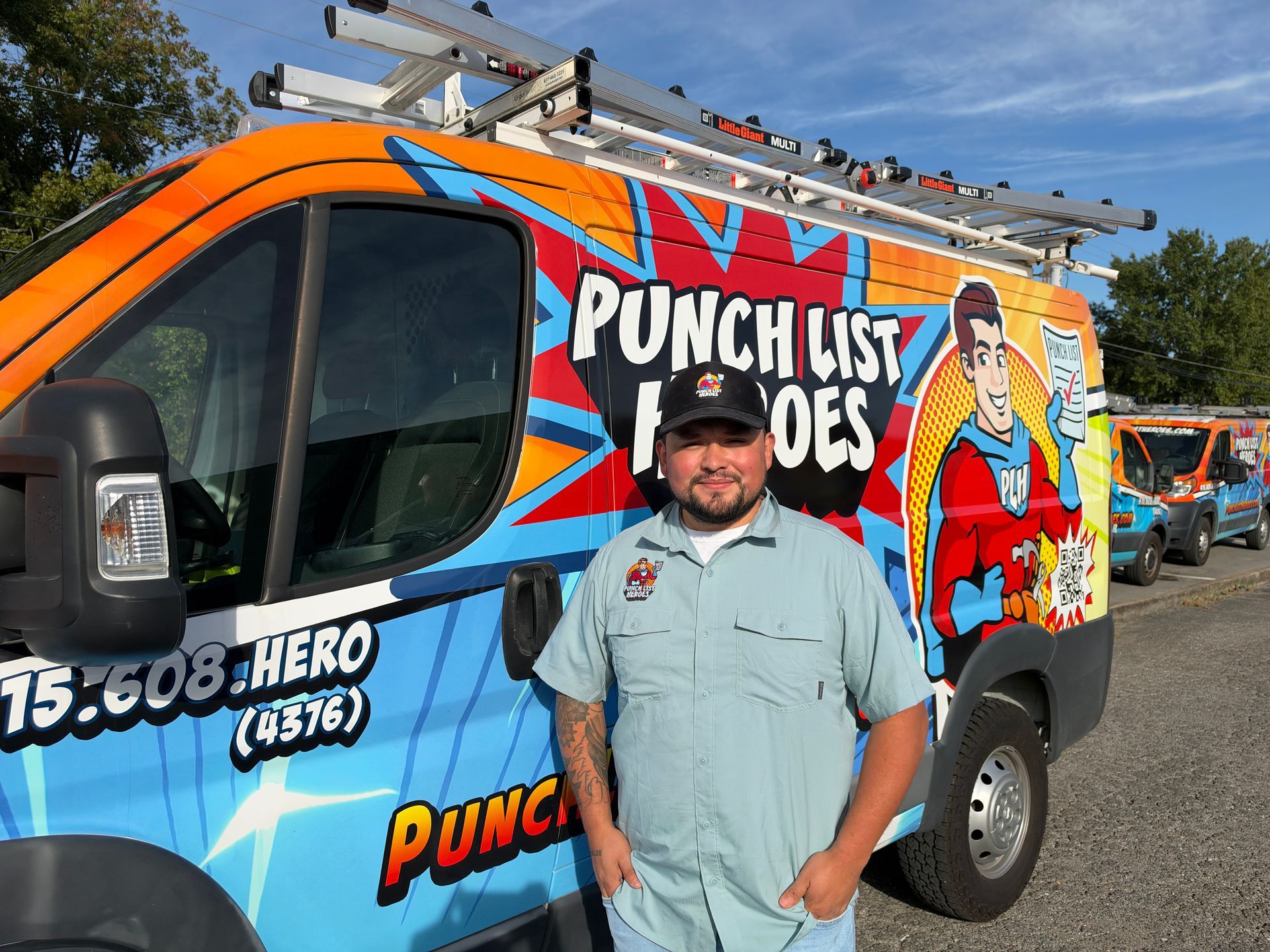 A young man is standing in front of a colorful van.