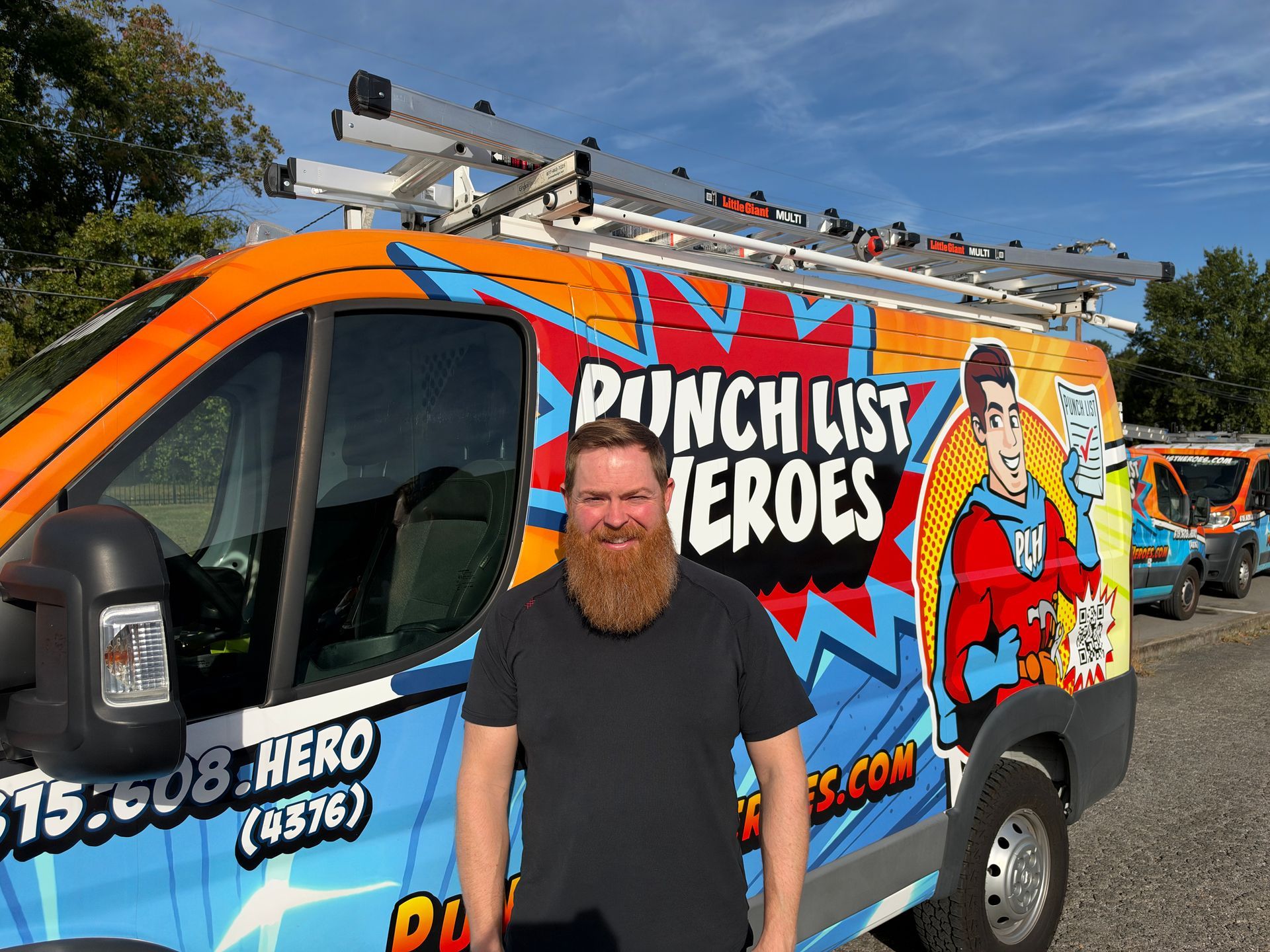 A young man is standing in front of a colorful van.