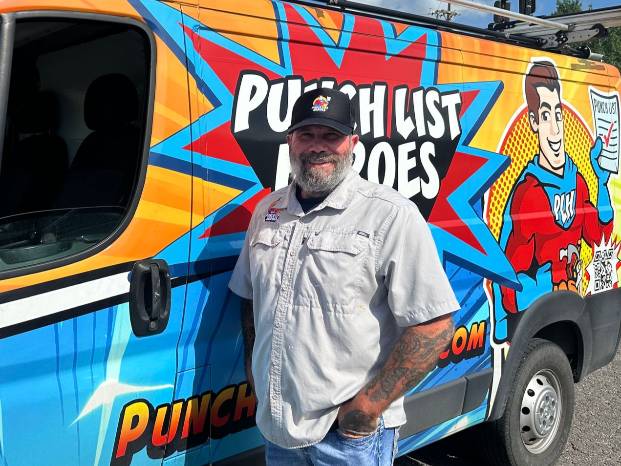 A man with a beard is standing in front of an orange van. A man with a beard is standing in front of an orange van.