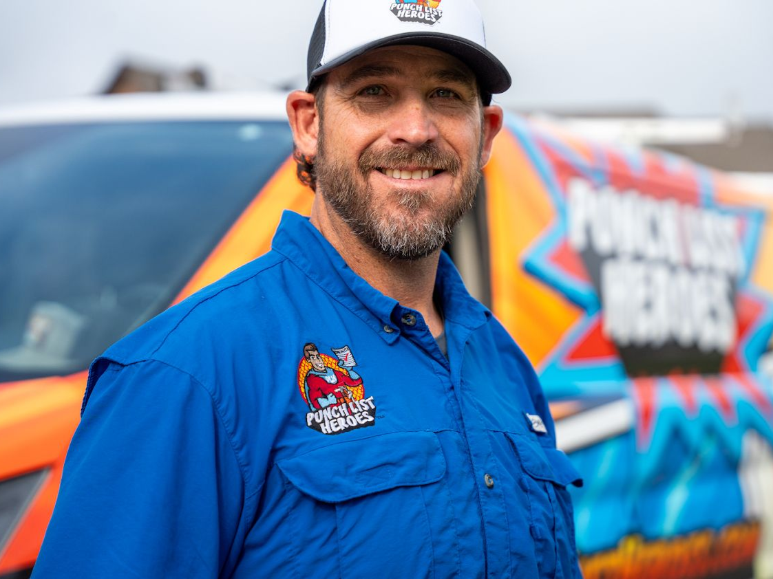 A young man is standing in front of a colorful van. A young man is standing in front of a colorful van.