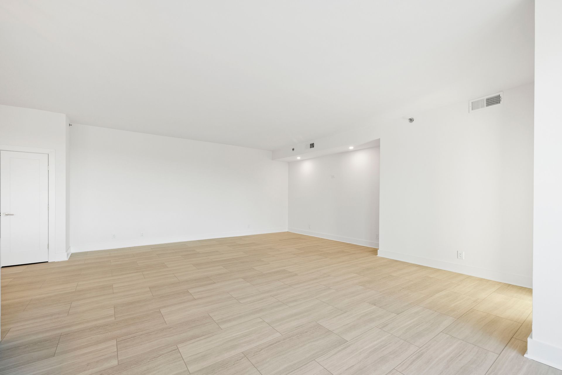 Empty room with wood floors and white walls.