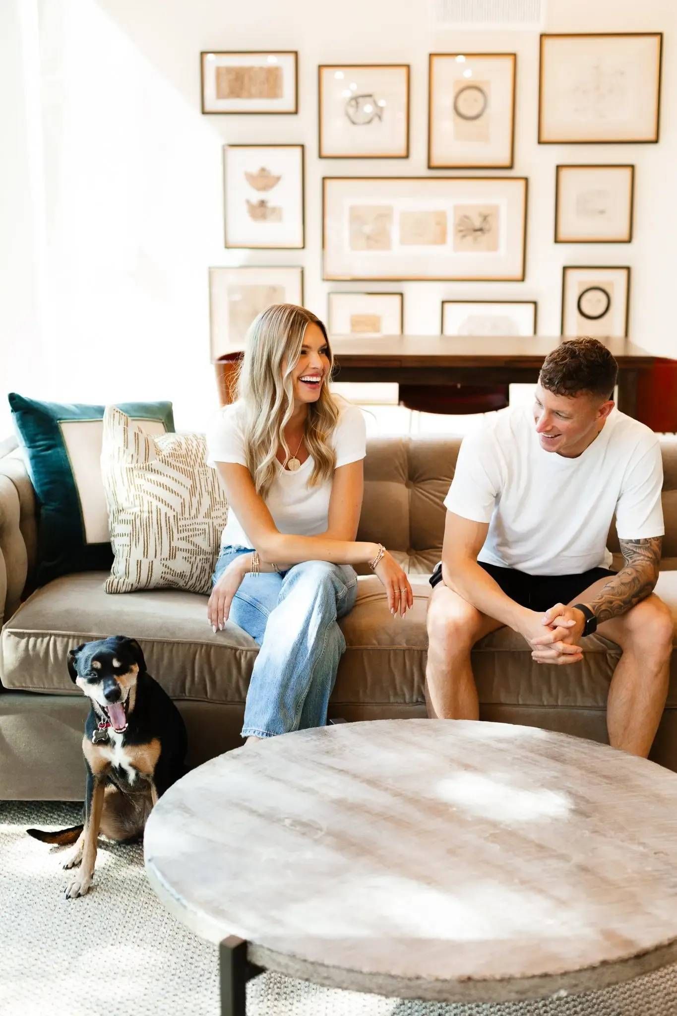 A man and a woman are sitting on a couch with a dog.