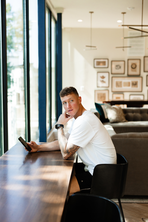 A man is sitting at a table looking at a tablet.