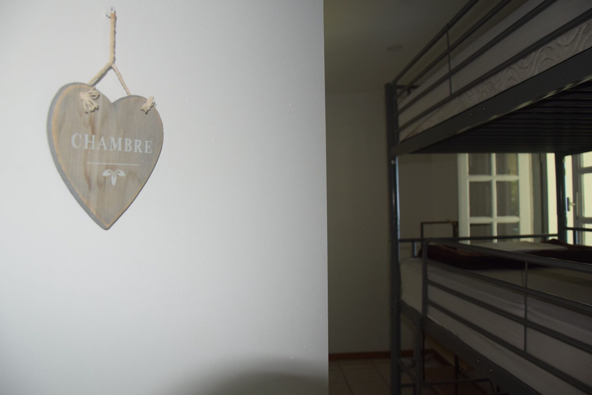 Une chambre avec des lits superposés et une pancarte indiquant chambre