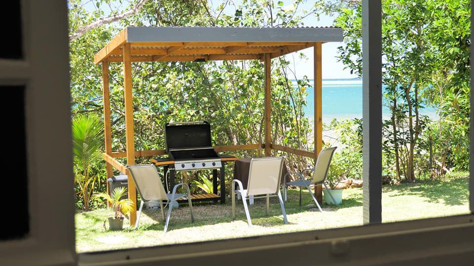 Un gazebo avec grill, chaises et table avec vue sur l'océan.