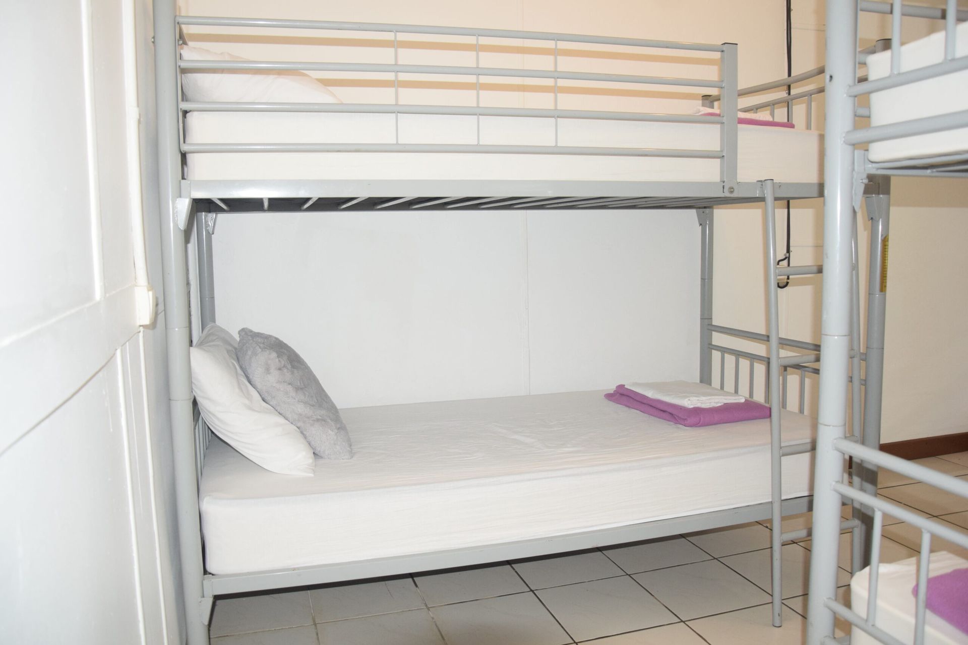Un lit superposé avec un matelas blanc et des draps violets
