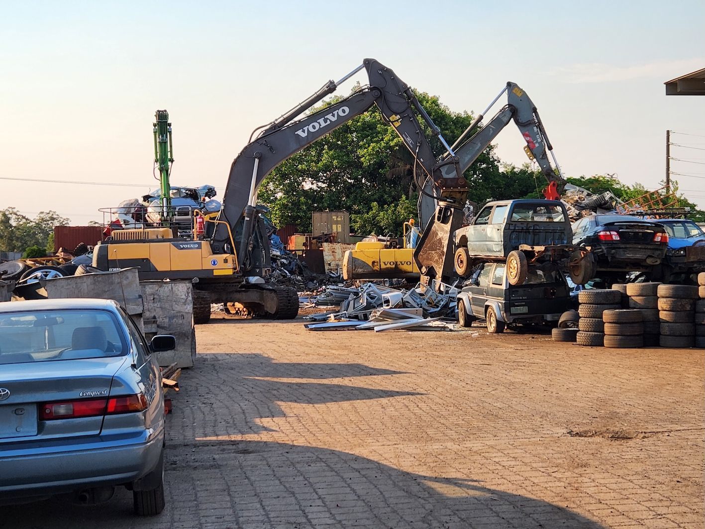 Red Excavator is Working on a Pile of Scrap Metal — Maryborough Recycling in Maryborough, QLD
