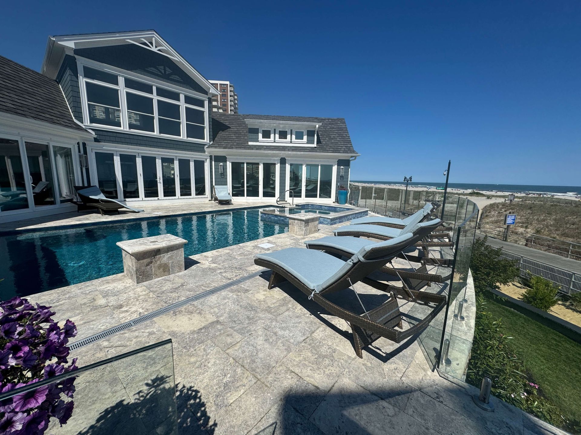 Modern coastal home with a pool and lounge chairs overlooking the ocean