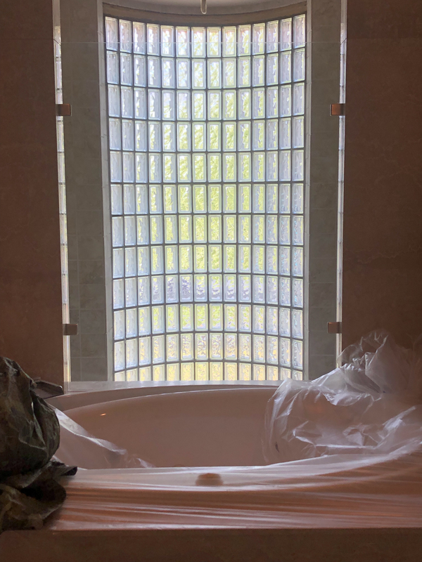 Bathroom with a large curved glass-block window and a sink/vanity in the foreground