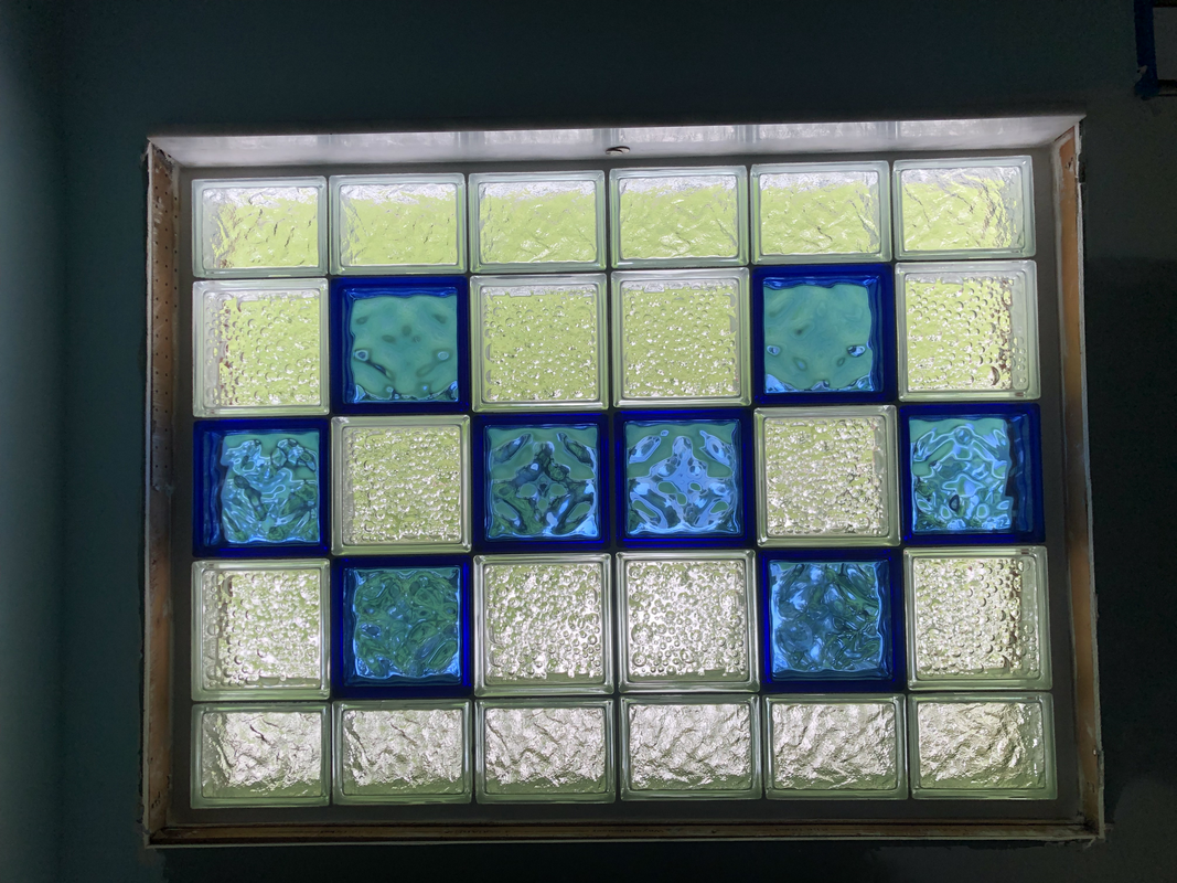 Abstract stained-glass pattern with blue and clear square tiles in a rectangular frame