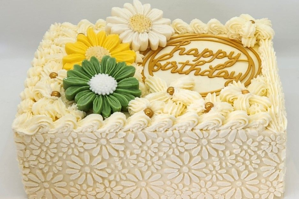 Square birthday cake with floral decorations and 