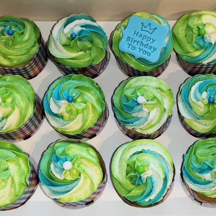 Cupcakes with green and blue frosting swirls, one with 