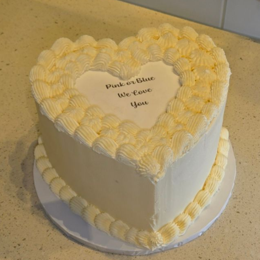 Heart-shaped cake with white frosting, text 