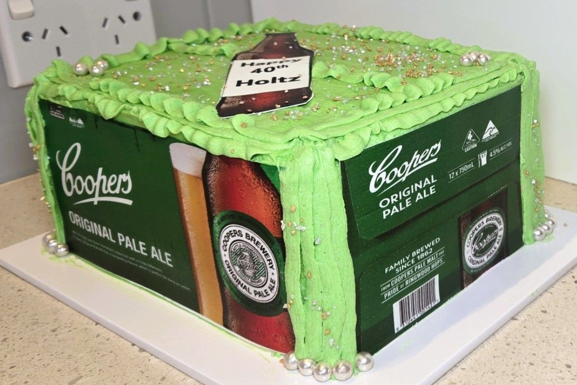 Cake decorated as a Coopers Pale Ale carton, green frosting, with beer bottle detail.