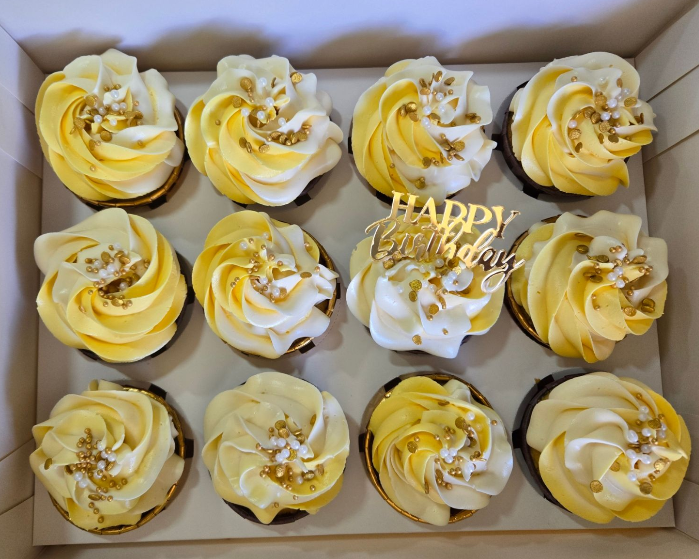 Cupcakes with green and blue frosting swirls, one with 