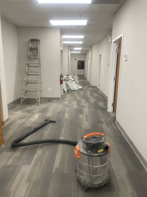 Construction materials and a ladder in a hallway with new flooring being installed