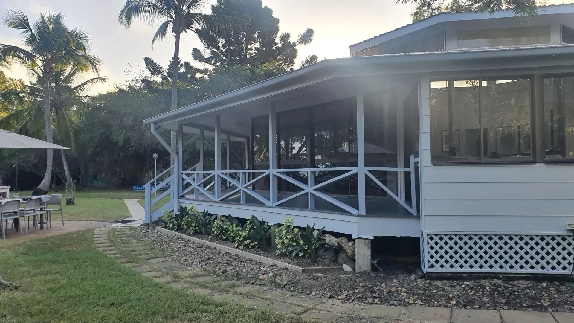 White House With Screened Porch, Surrounded by Trees and Grass — Keppel Coatings in Pacific Heights, QLD