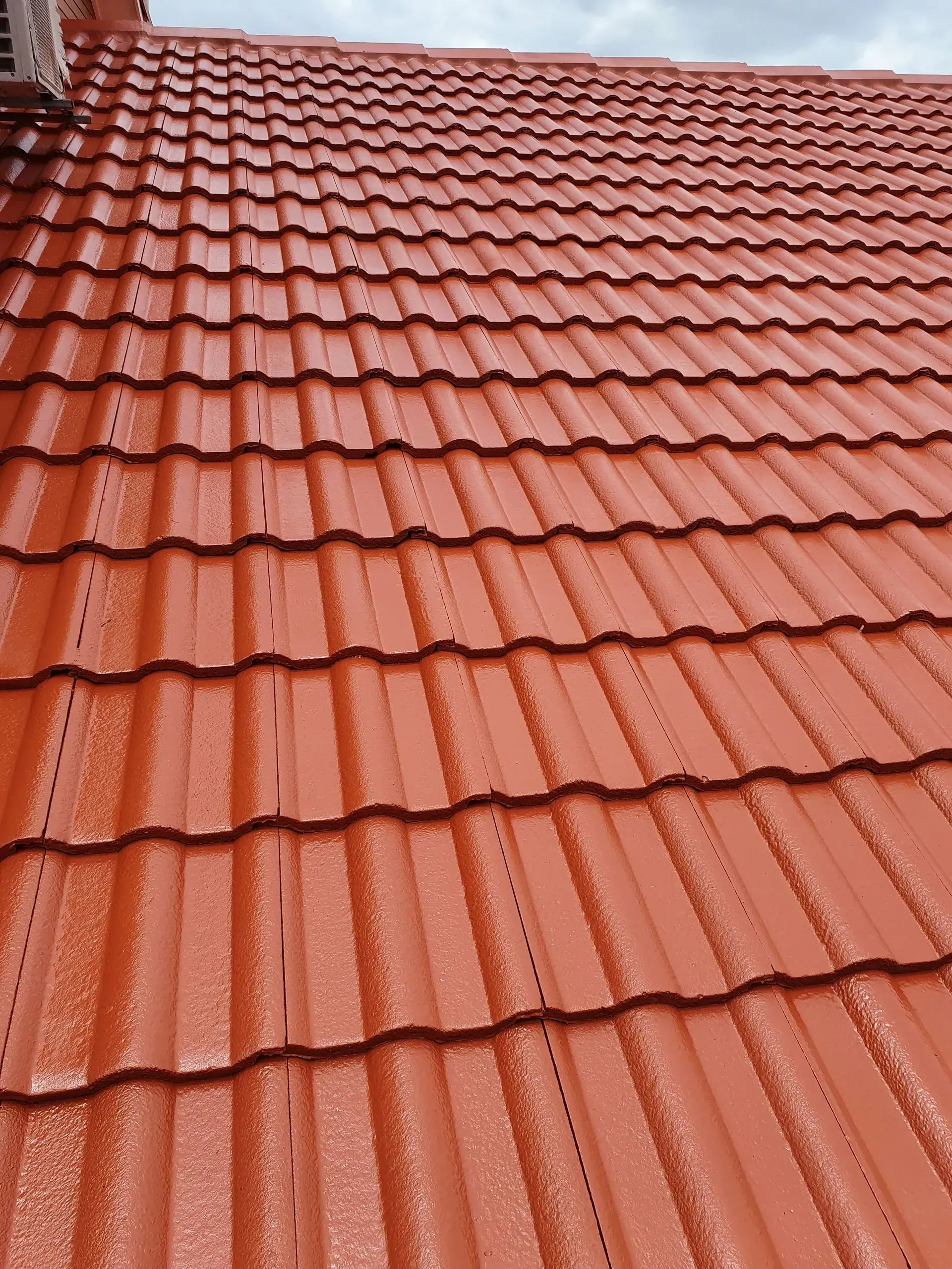 Red Metal Roof Tiles on a House — Keppel Coatings in Pacific Heights, QLD