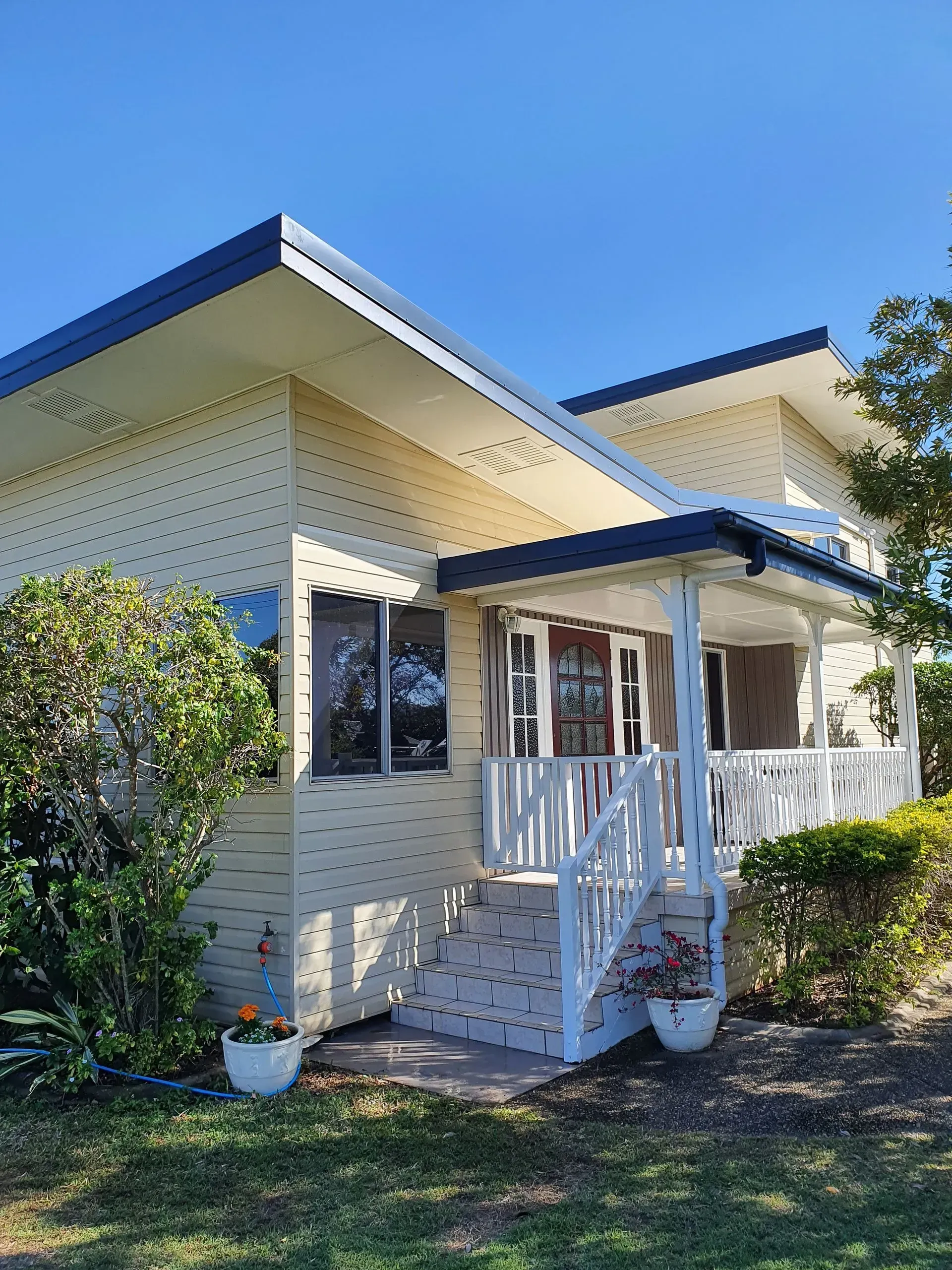 Cream-colored House With Dark Blue Roof — Keppel Coatings in Pacific Heights, QLD