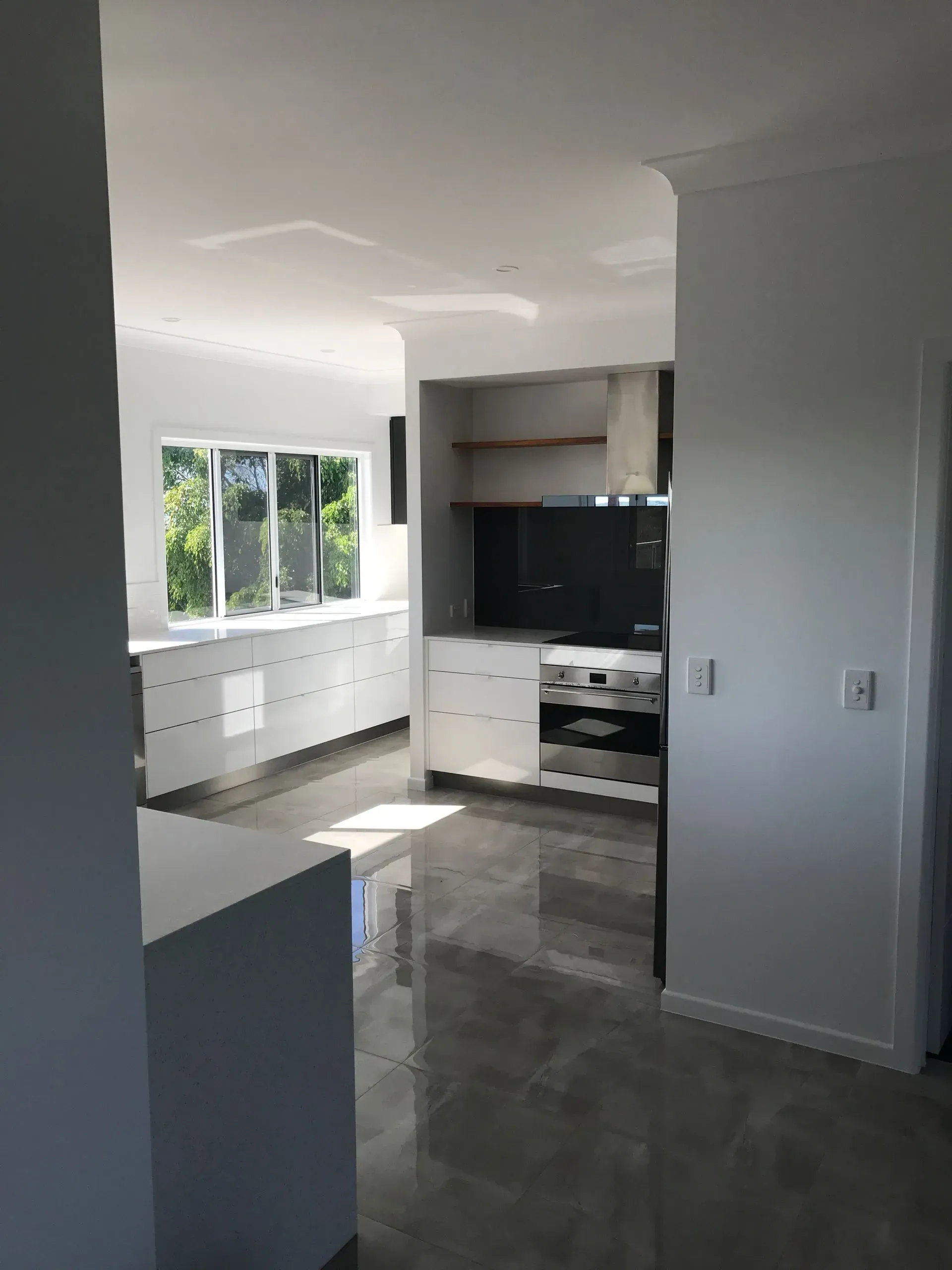A Modern, Bright Kitchen With White Cabinets — Keppel Coatings in Pacific Heights, QLD