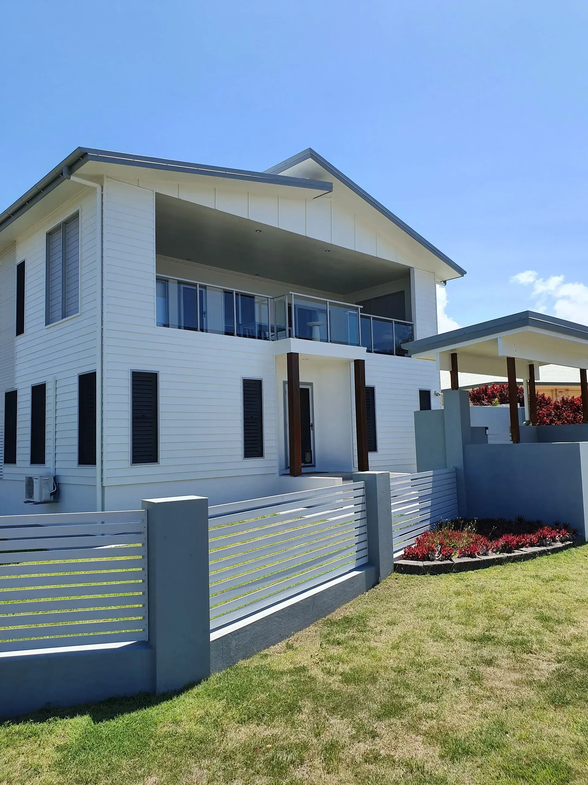 Two-story White House With a Balcony and Fence — Keppel Coatings in Pacific Heights, QLD