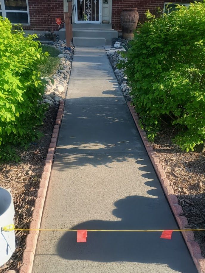 Front walkway to a brick house, with a yellow caution tape barrier and green bushes on both sides.