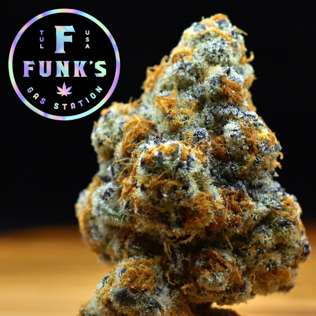 Close-up of a frosty orange-green cannabis bud with a Funk’s logo in the corner