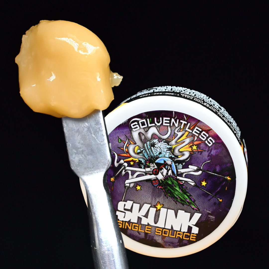 Yellow dab on a dab tool beside a purple SKUNK single-source concentrate container