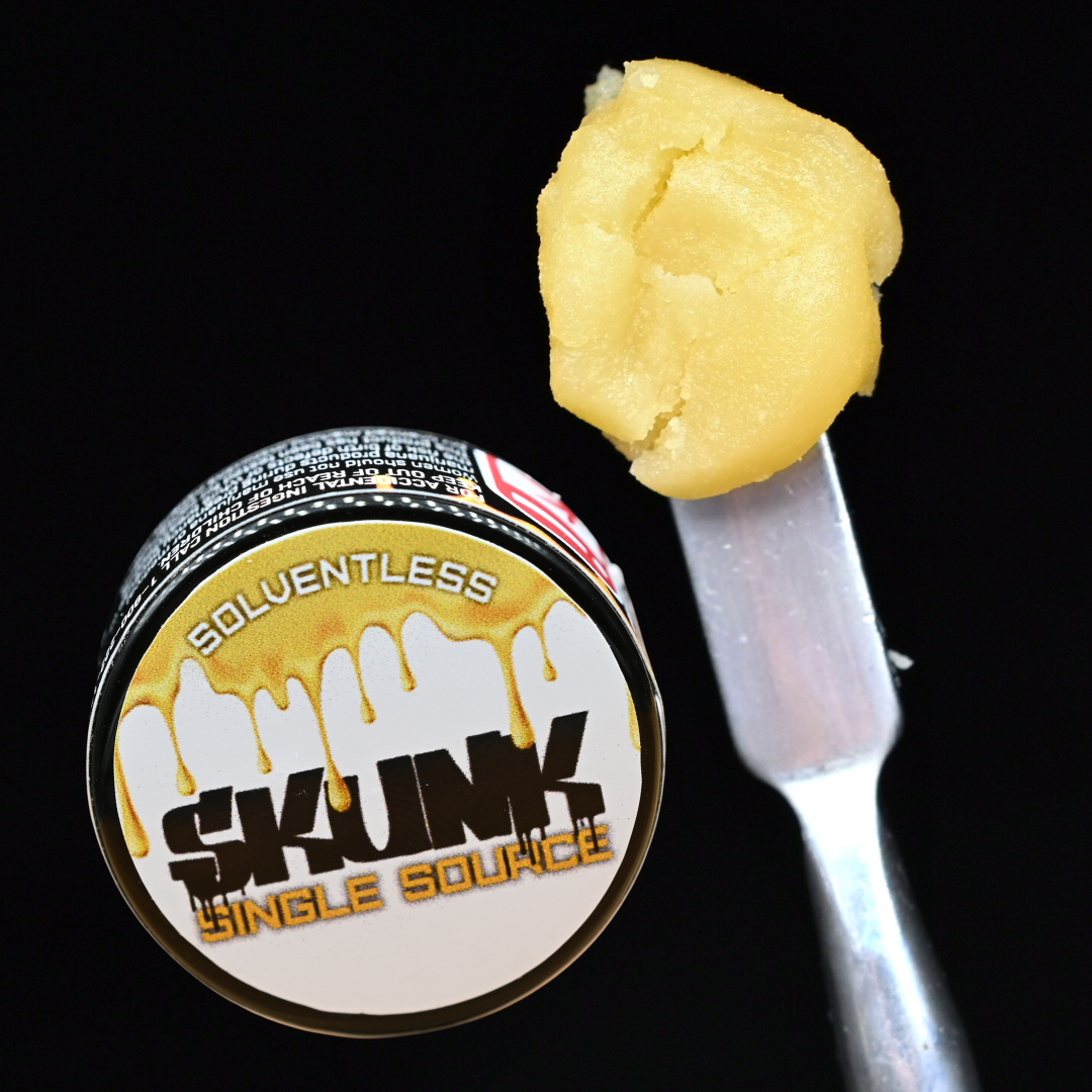 Small jar labeled “SOLVENTLESS SKWIM single source” beside a spoonful of yellow concentrate on a fork.