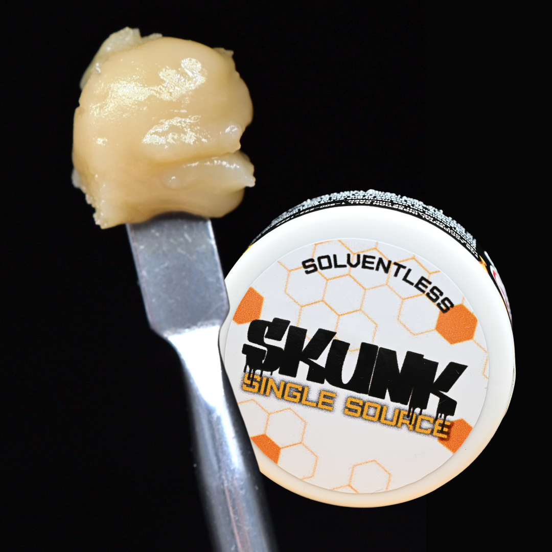 Cannabis concentrate on a dab tool beside a jar labeled “SKUNK Single Source”