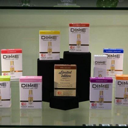 DIME skincare product boxes arranged on a glass display with a black pedestal center
