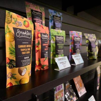 Assorted cannabis-flavored drink pouches displayed on a store shelf with price tags