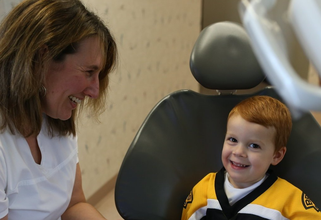 A little boy wearing a yellow and white shirt with the word Bruins on it