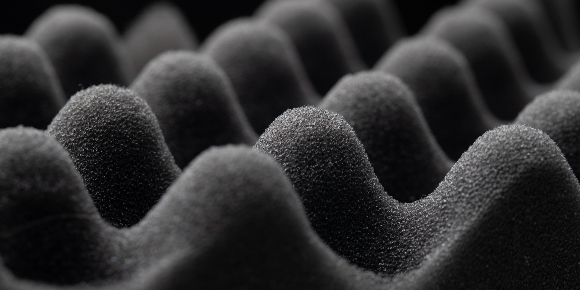 Close-up of black acoustic foam with a wave-like pattern, used for sound dampening.