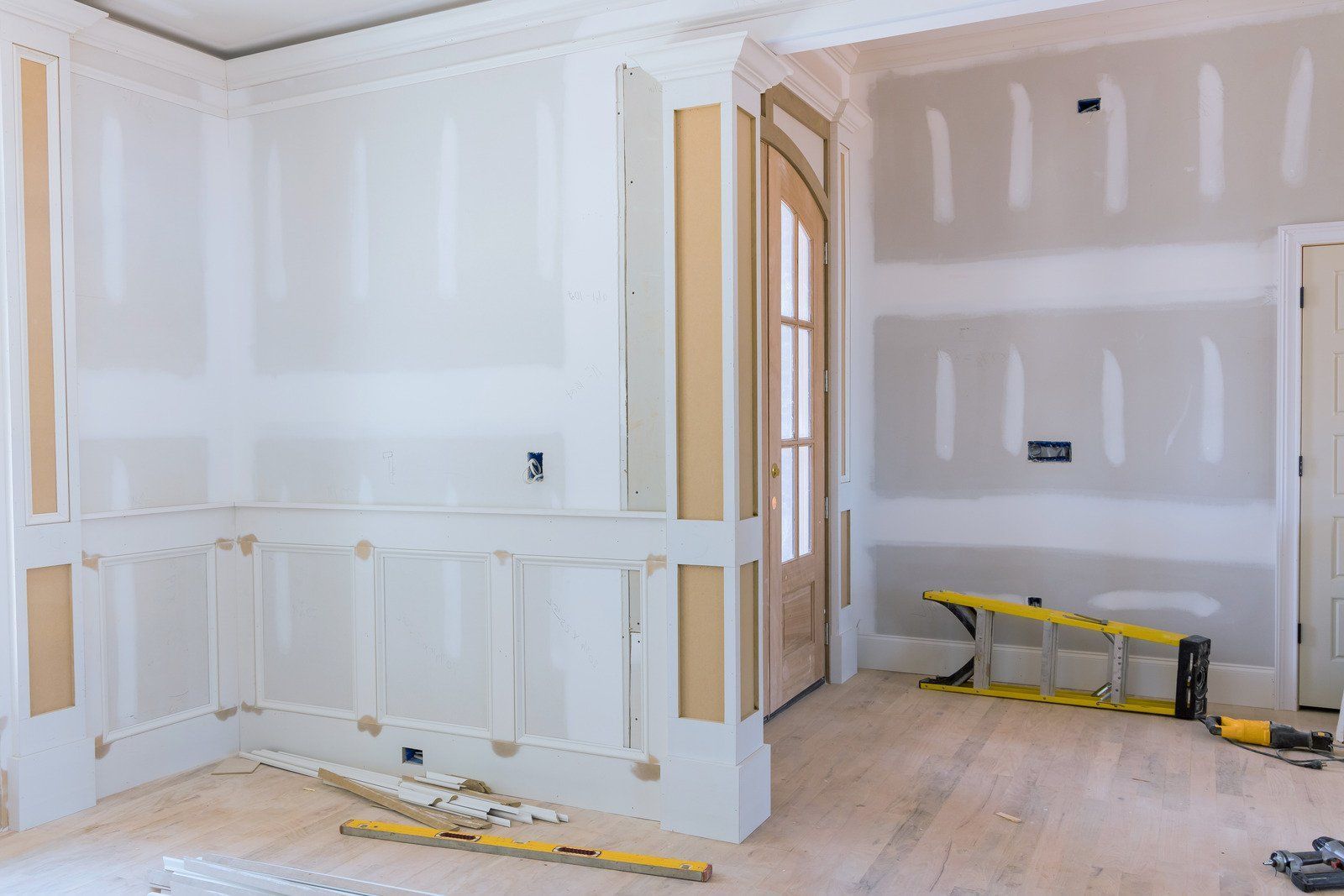 Interior room under renovation with drywall and wooden trim.