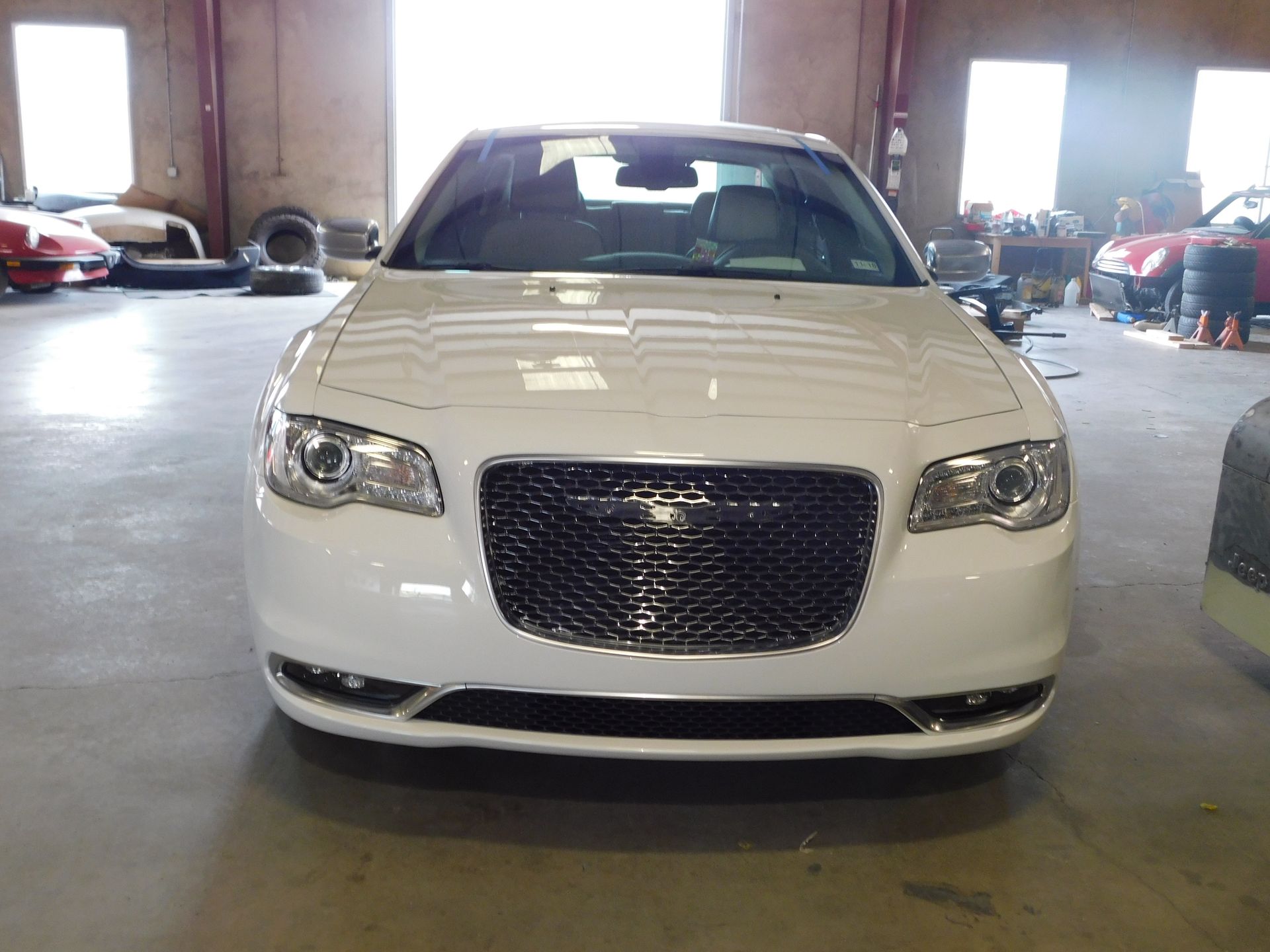 White Chrysler 300 sedan parked inside a garage.