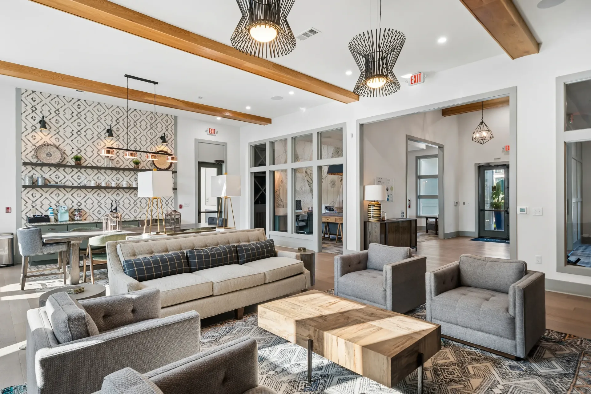 Modern lounge area with sofas, armchairs, a coffee table, and a decorative shelving unit at Atlantic on the Boulevard in North Charleston, SC.